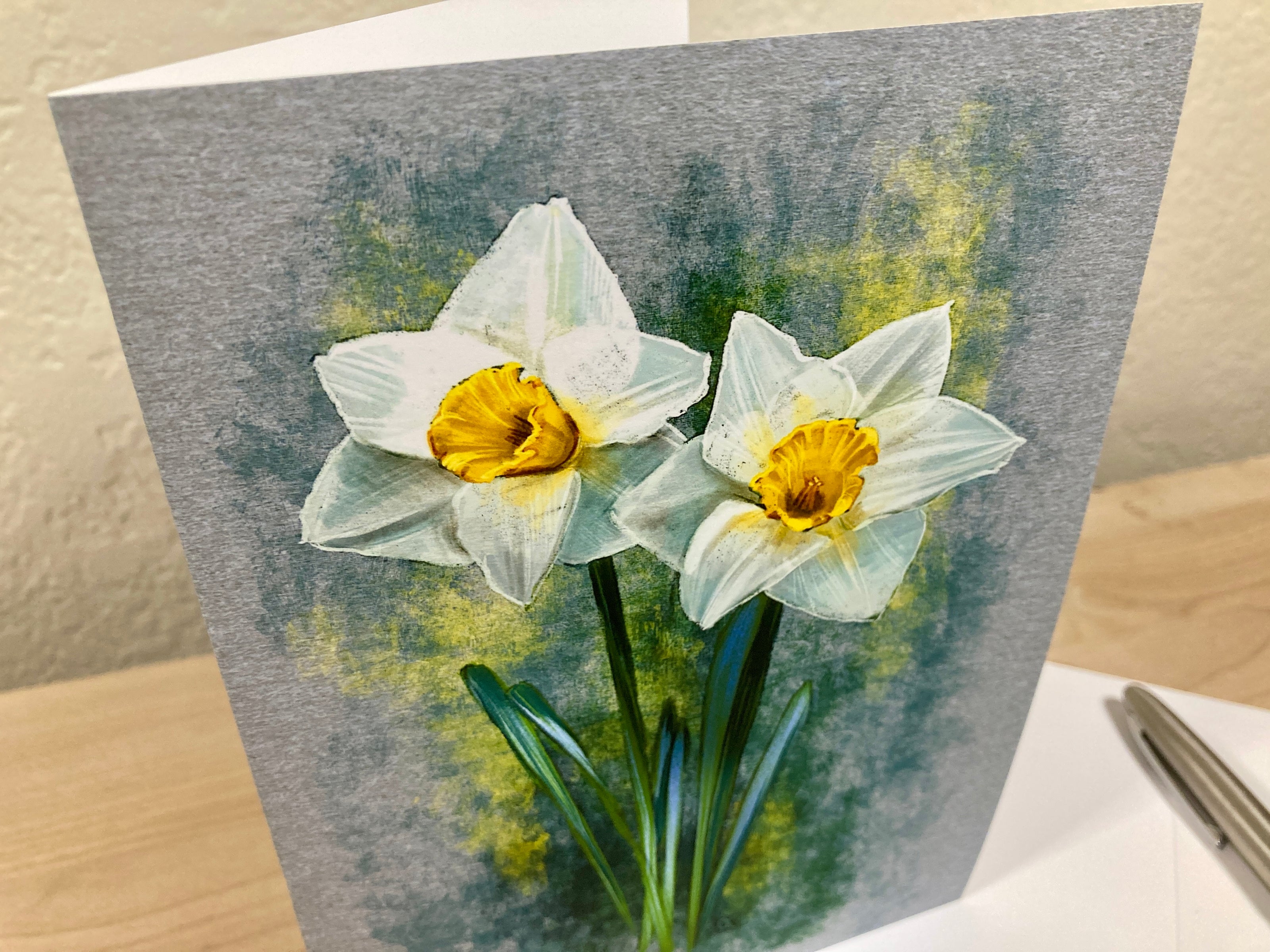 Greeting card with two white flowers with yellow centers on a gray background