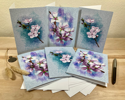 Set of greeting cards with floral designs on a wooden surface