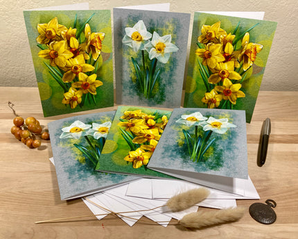 Set of greeting cards with floral designs on a wooden surface.