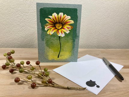 Greeting card with a sunflower design on a wooden surface with decorative elements.
