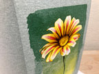 Yellow flower with red accents on a textured green background