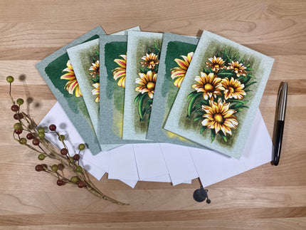 Set of greeting cards with floral design on a wooden surface