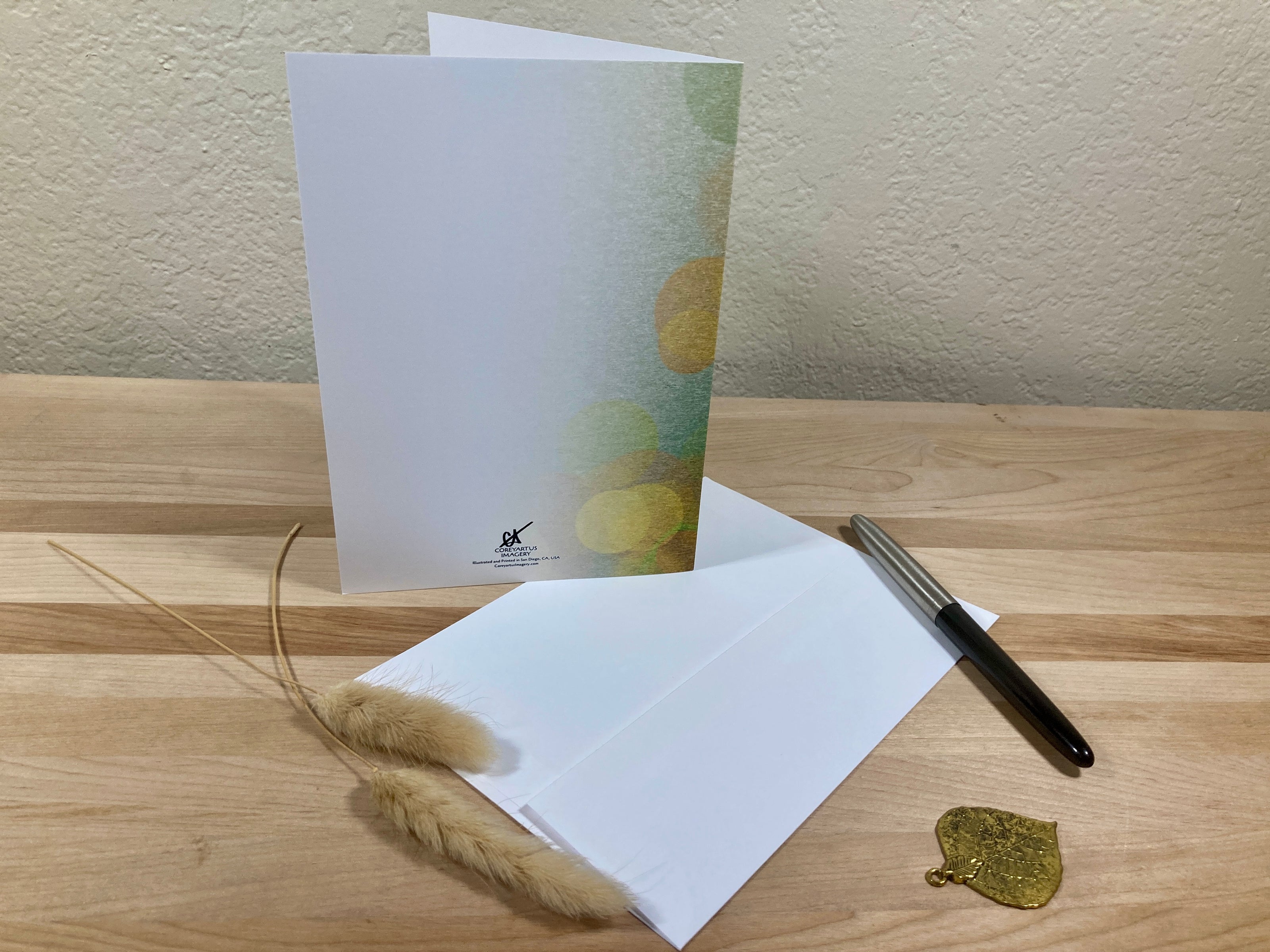 Greeting card with envelope and pen on a wooden surface