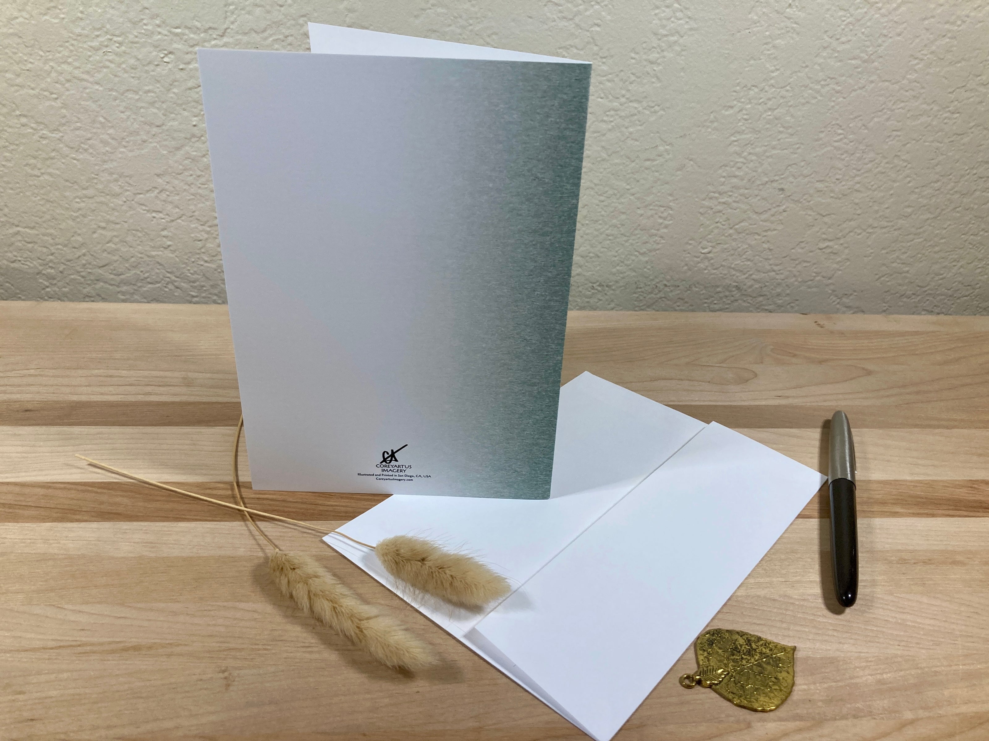 Greeting card with envelope and decorative elements on a wooden surface