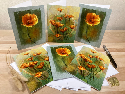 Set of floral greeting cards on a wooden surface with a pen and decorative item.
