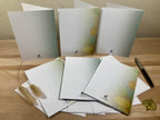 Set of stationery items including envelopes and a pen on a wooden surface.