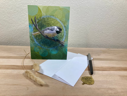 Greeting card with a bird illustration on a wooden surface with an envelope and pen.