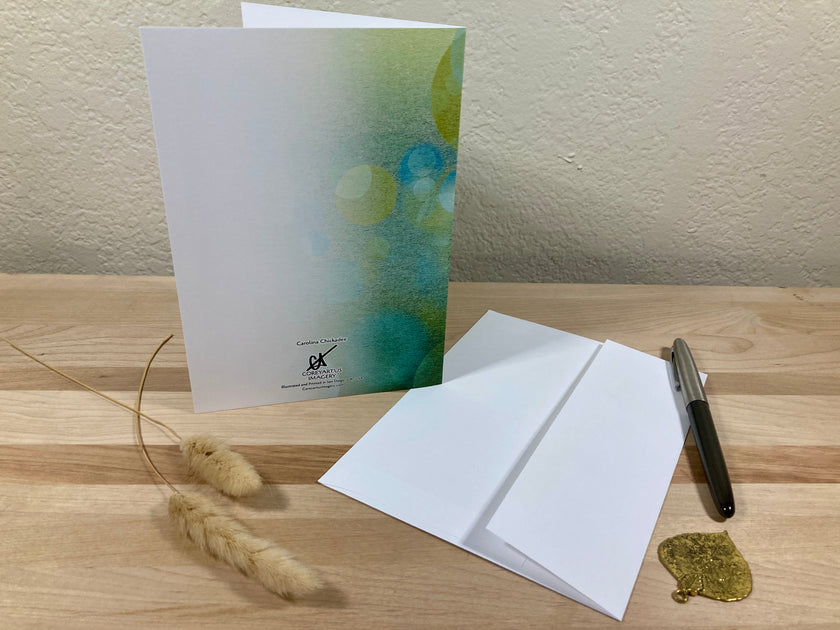 Greeting card with envelope and pen on a wooden surface