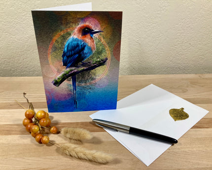 Greeting card with a colorful bird design on a wooden surface with a pen and envelope.