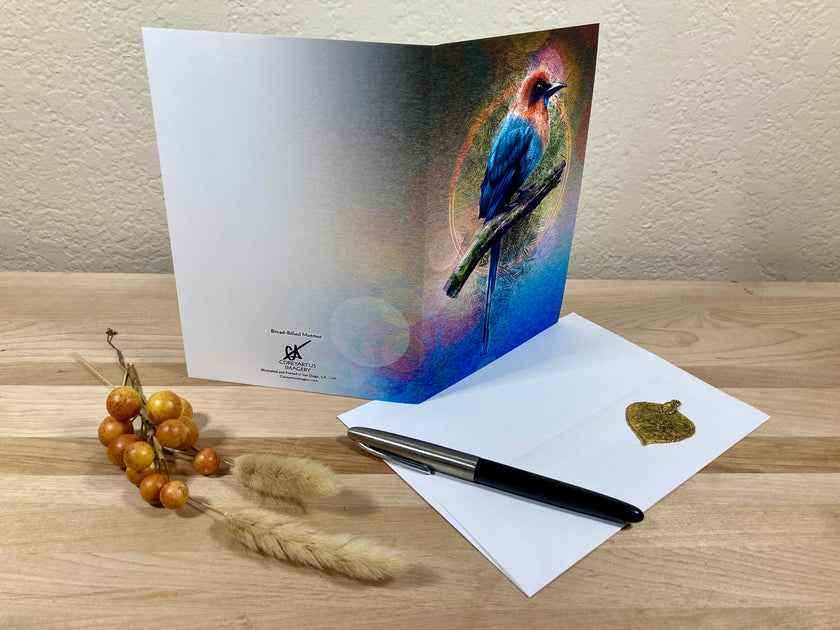 Greeting card with a bird design on a wooden surface with a pen and decorative items.