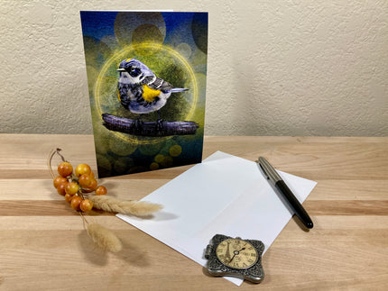 Greeting card with a bird design on a wooden surface with paper and pen.