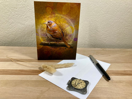 Greeting card with a bird design on a wooden surface with a pen and decorative items.