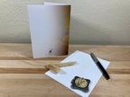 Greeting card with feather and pen on a wooden surface
