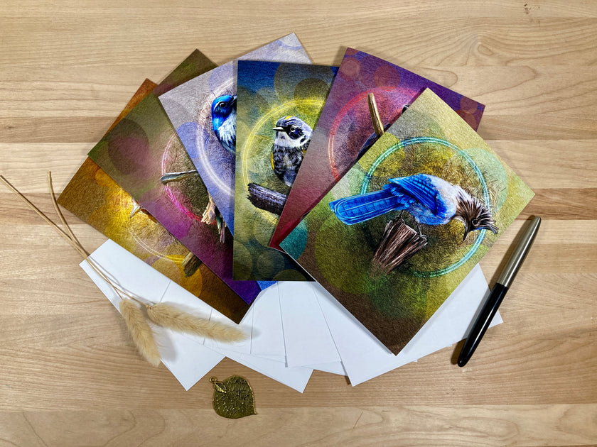 Set of greeting cards with bird illustrations on a wooden surface