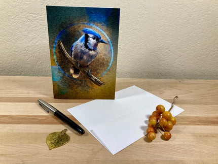 Greeting card with a blue jay design on a wooden surface with a pen and grapes.