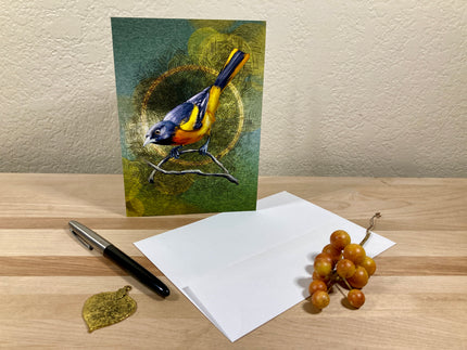 Greeting card with a bird design on a wooden surface with a pen and grapes.