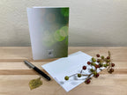 Greeting card with pen and decorative elements on a wooden surface