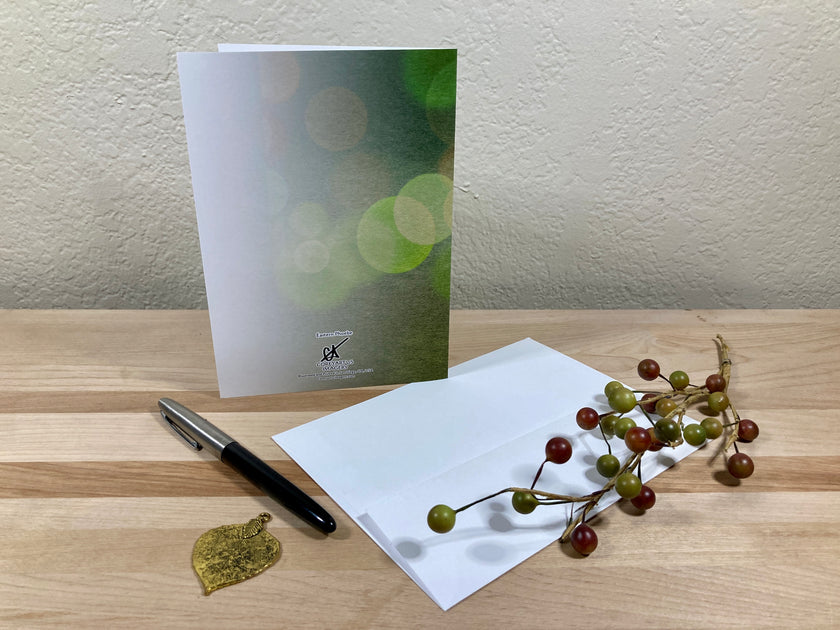 Greeting card with pen and decorative elements on a wooden surface