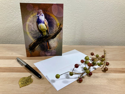 Greeting card with a bird design on a wooden surface with a pen and decorative branch.