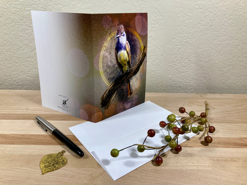 Greeting card with a bird design on a wooden surface with a pen and decorative branch.