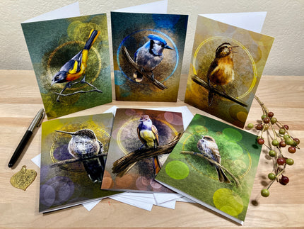 Set of six greeting cards with bird illustrations on a wooden surface.