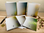 Set of greeting cards with a pen and decorative elements on a wooden surface