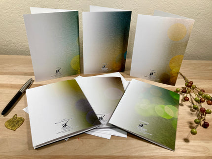 Set of greeting cards with a pen and decorative elements on a wooden surface
