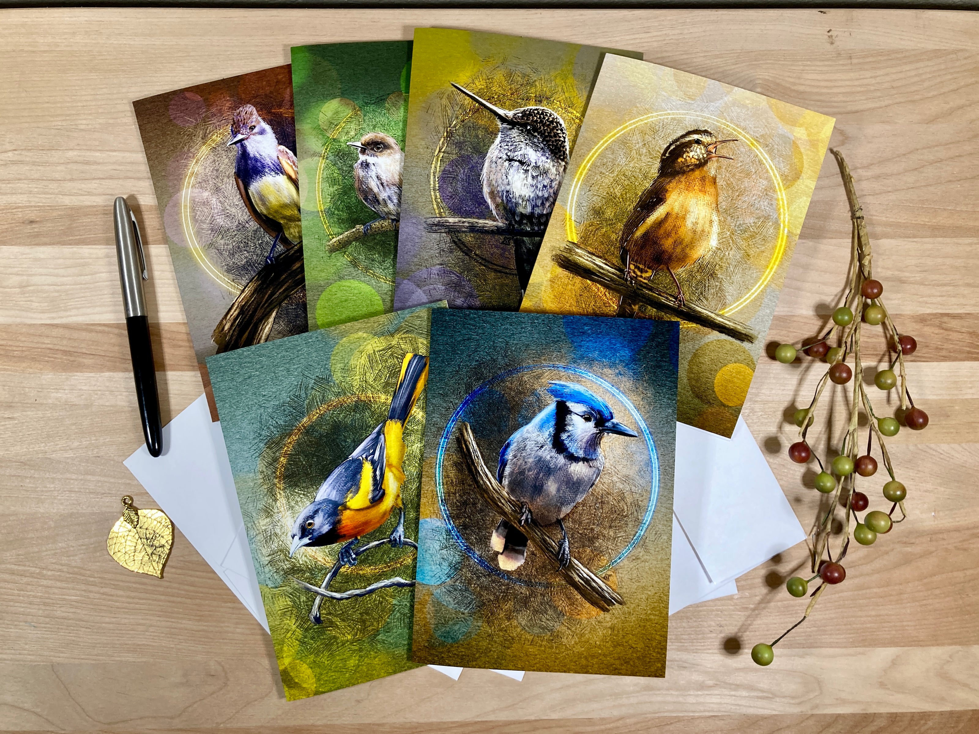 Set of greeting cards with bird illustrations on a wooden surface.