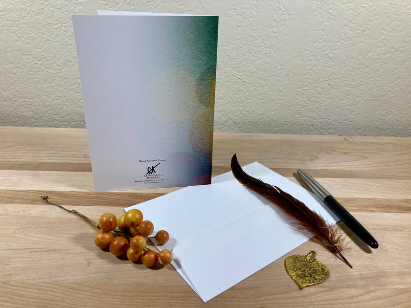 Greeting card with envelope, pen, and decorative elements on a wooden surface