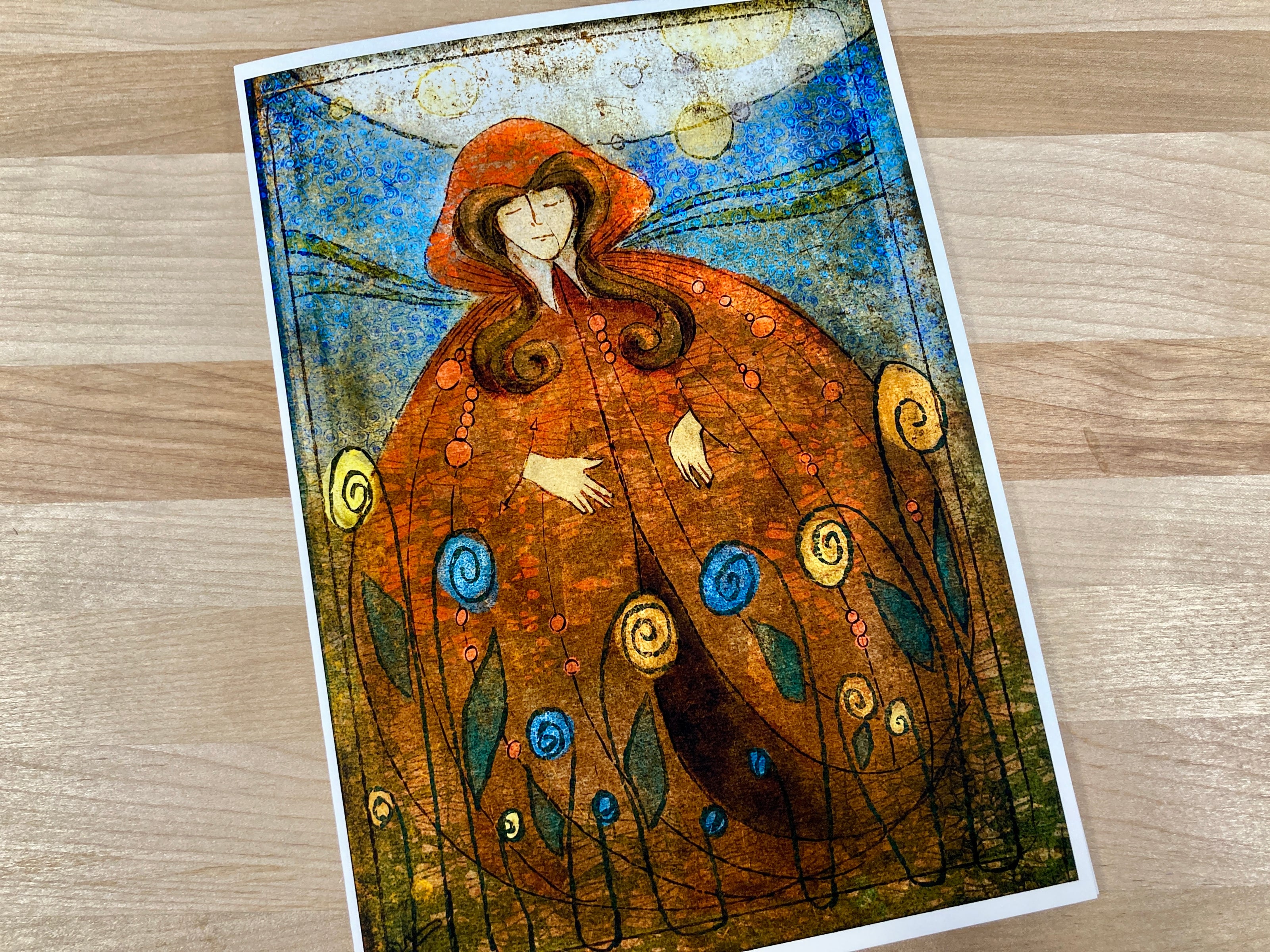 Artistic depiction of a figure in a flowing garment with decorative elements on a wooden surface