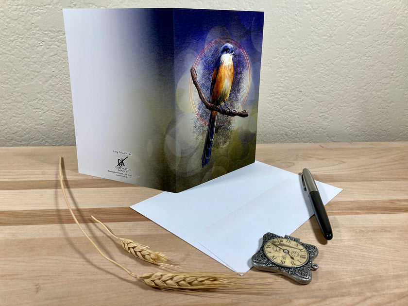 Greeting card with a bird design on a wooden surface with an envelope and pen.