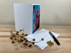 Greeting card with nature-themed design on a wooden surface with decorative elements.