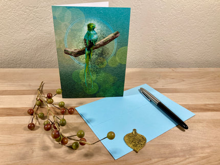 Greeting card with a green parrot design on a wooden surface with a pen and decorative item.