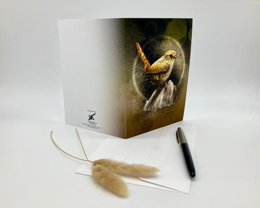 Greeting card with a bird design on a white surface with a pen and decorative item.