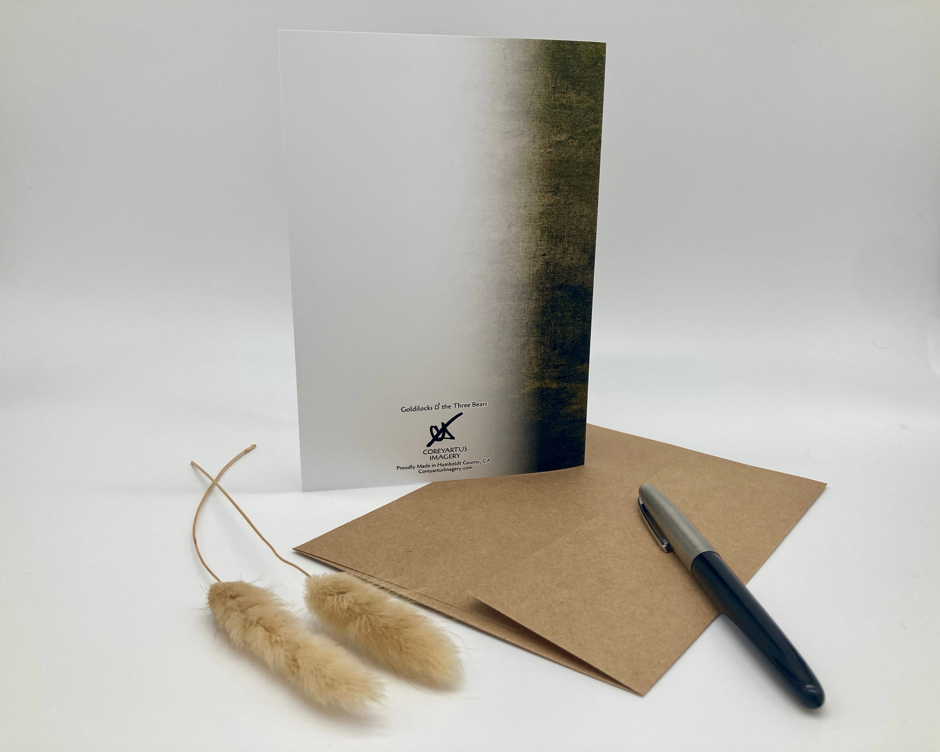 Notebook, pen, and dried plant on a white background