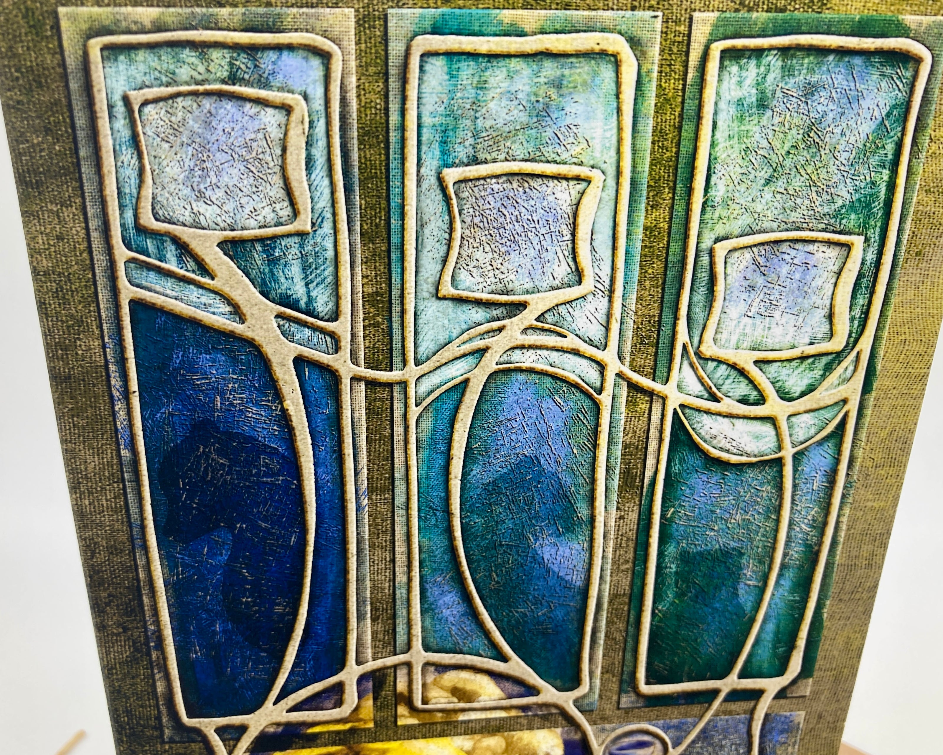 Decorative tile with abstract design in blue, green, and gold on a white background