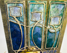 Decorative tile with abstract design in blue, green, and gold on a white background