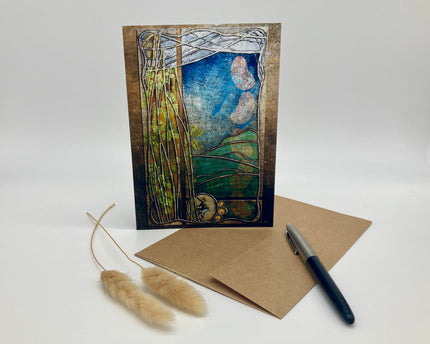 Artistic greeting card with nature-themed design, brown envelope, and pen on a white background