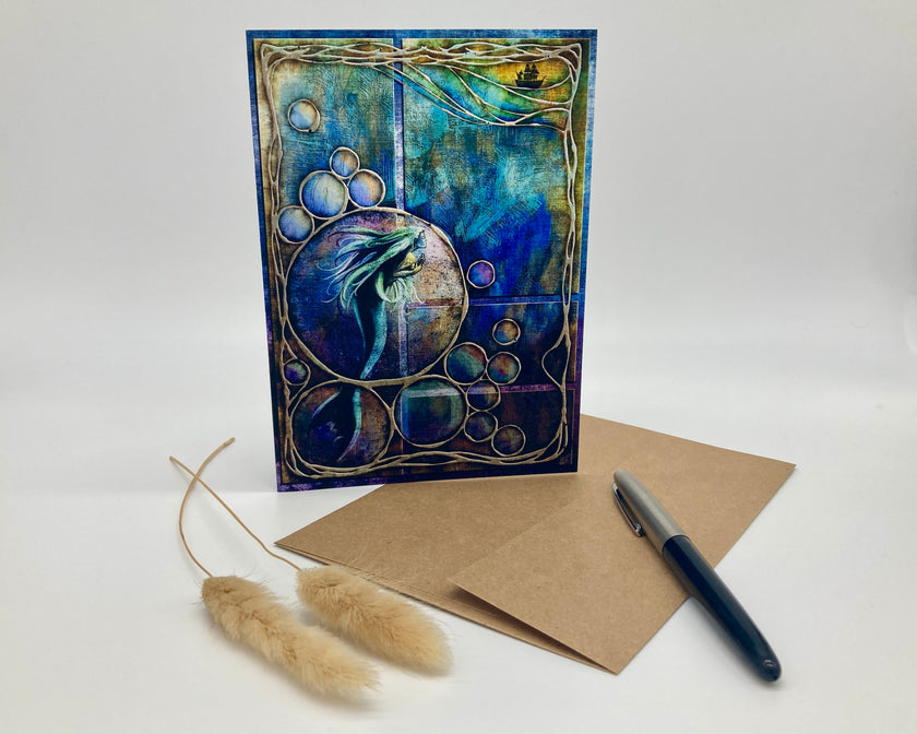 Artistic card with abstract design, brown envelope, and pen on a white background
