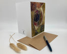 Greeting card with artistic design, envelope, and pen on a white background