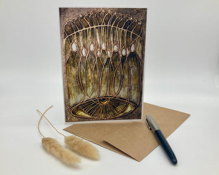 Greeting card with artistic design, envelope, and pen on a white background