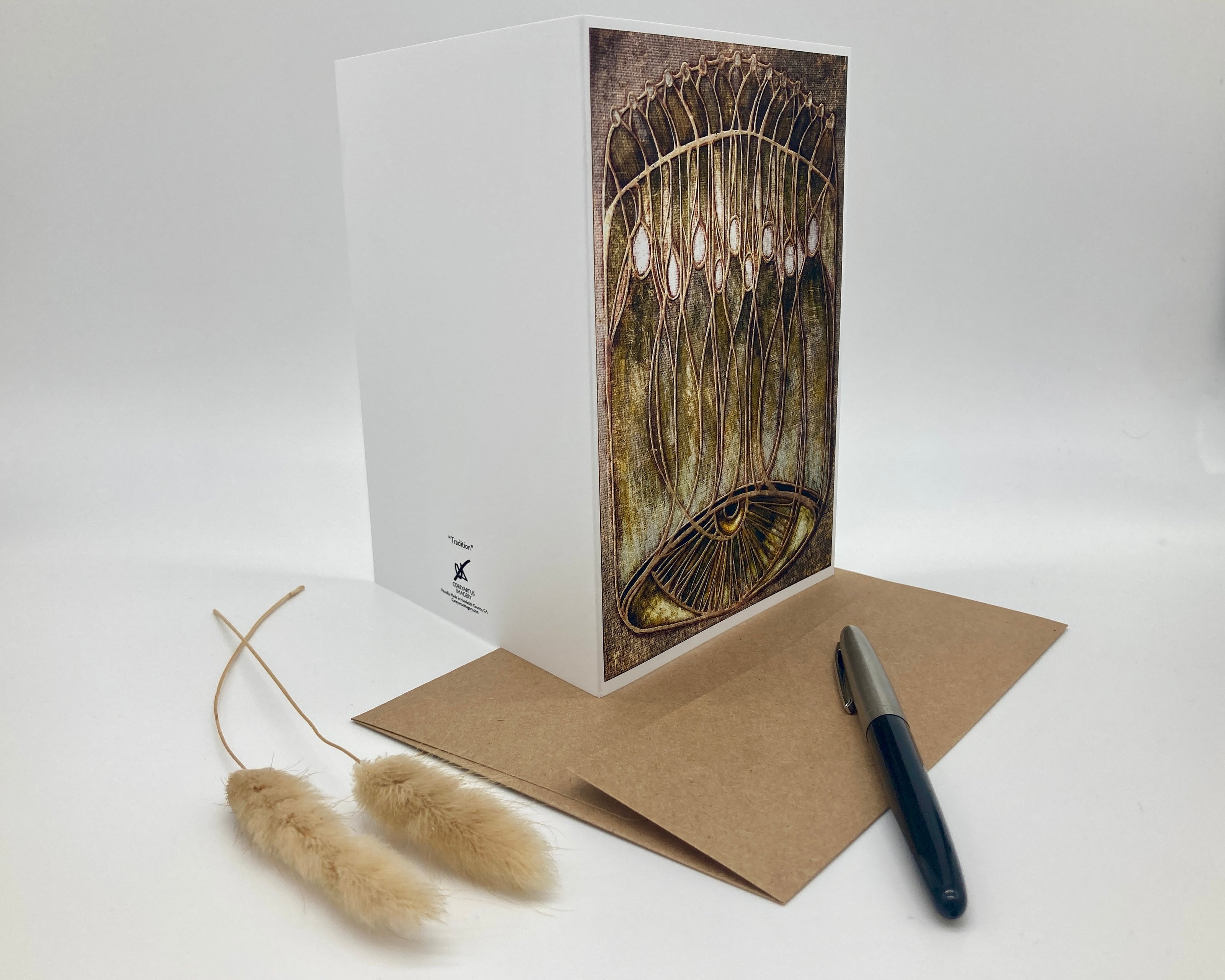 Greeting card with artistic design, envelope, and pen on a white background