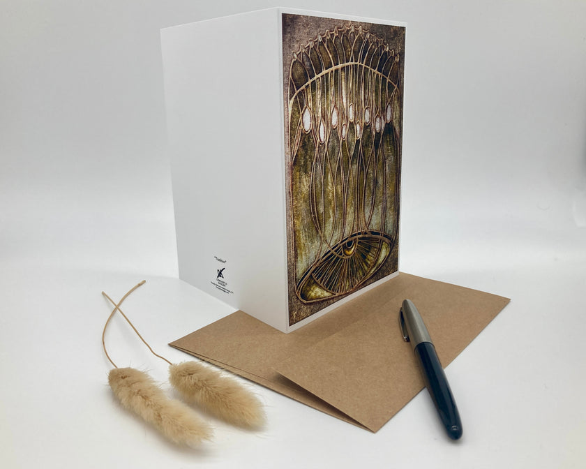 Greeting card with artistic design, envelope, and pen on a white background
