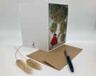 Greeting card with nature-themed design, pen, and dried plant on a white background