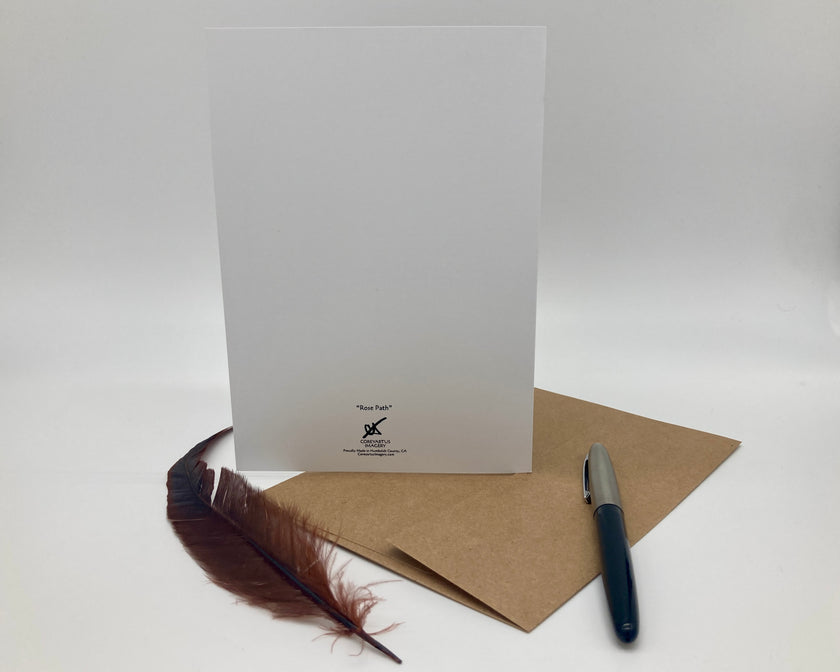 White card with a brown envelope and feather on a white background