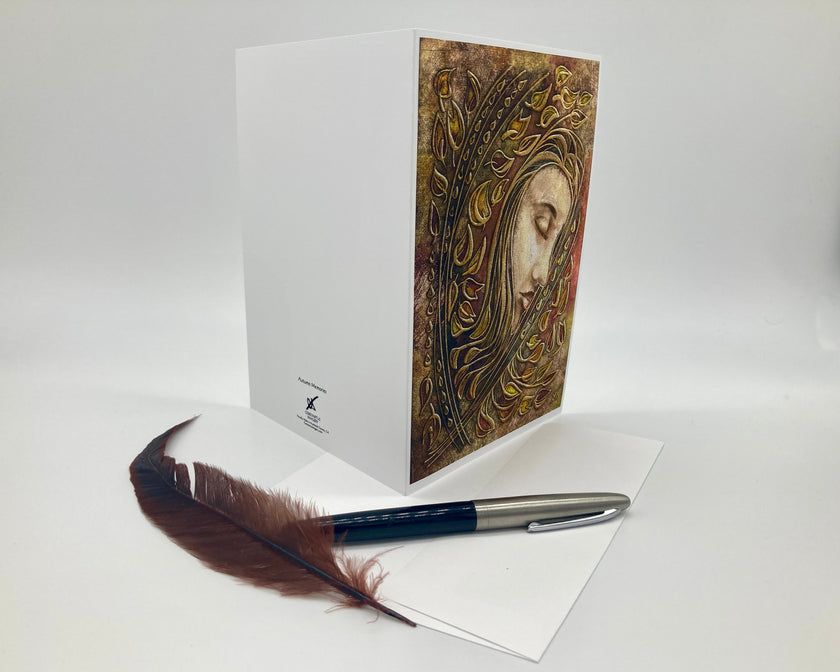 Greeting card with artistic design of a face, feather pen, and white paper on a light gray background