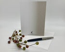 Greeting card with pen and decorative branch on a white background