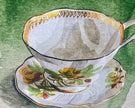 Teacup and saucer with floral design on a green background