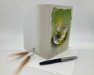 Greeting card with floral design and pen on a white surface