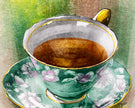 Decorative teacup with floral design on a saucer filled with coffee.